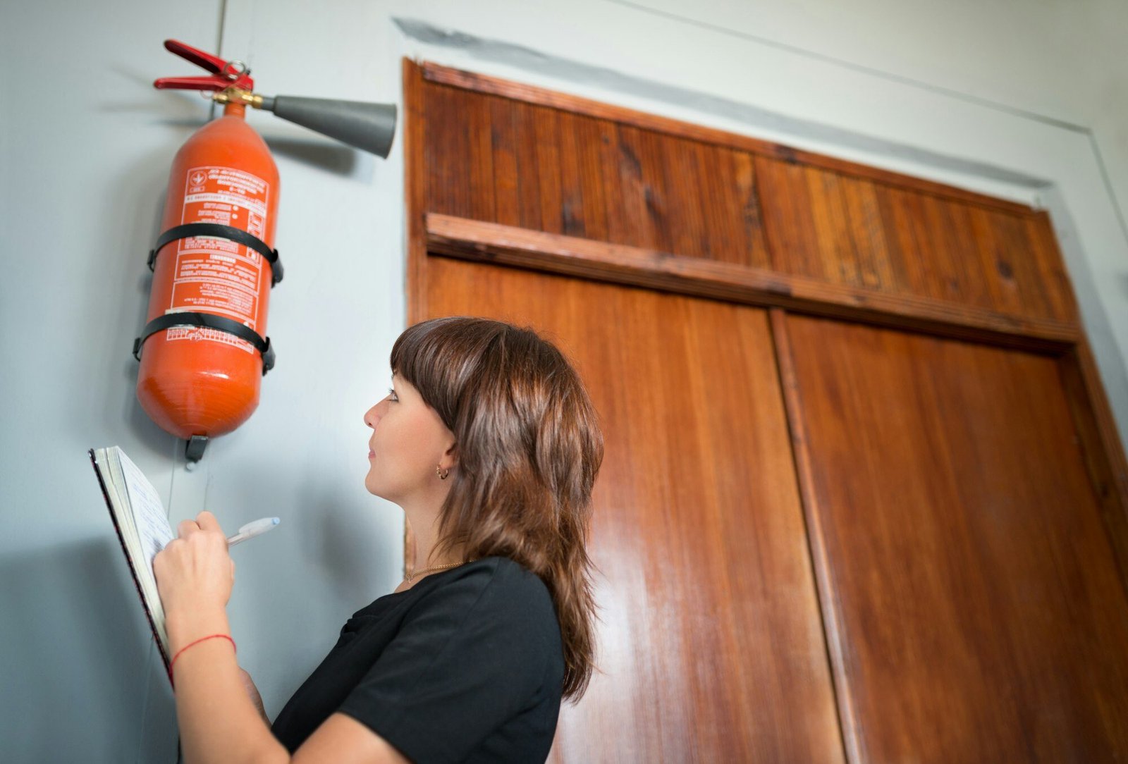 Young woman fire inspector writes in office